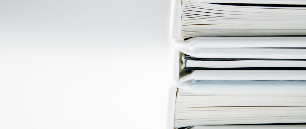 Three legal binders stacked on top of one another